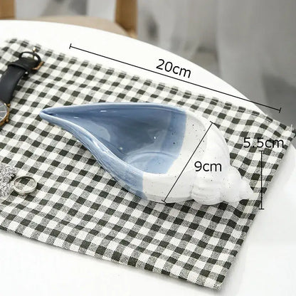 A blue and white ceramic marine life clamshell tray with glossy glaze and subtle exterior speckles for decorbites ceramic marine decor