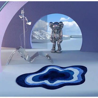 A sleek silver metallic kaws companion figurine stands in a modern room with a blue and white decorbites cloud shaped tufted rug