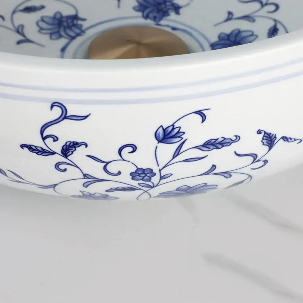 White porcelain basin set featuring blue floral patterns with a pop drain for bathroom sink use
