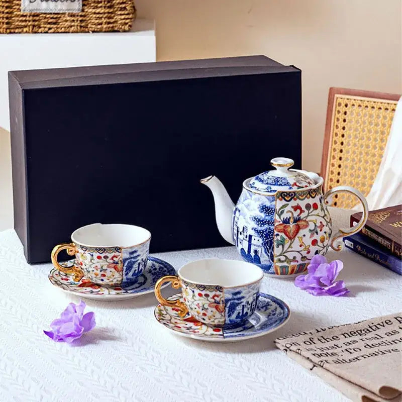 Blue white porcelain gilded coffee mug with gold accents featuring intricate floral and landscape decorbites blue white design