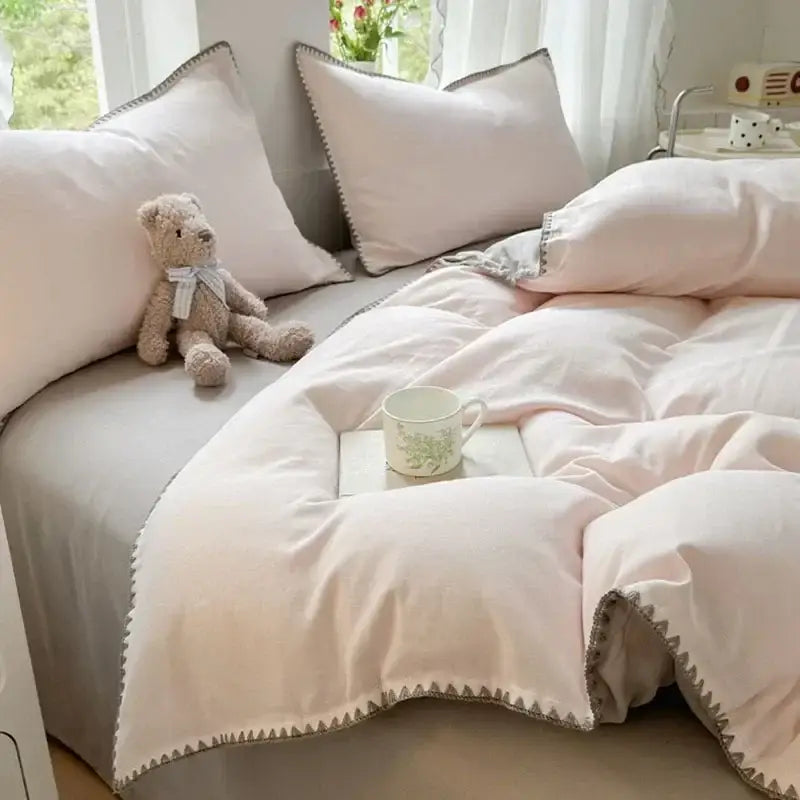 Soft blush pink cotton bedding set with subtle gray zigzag stitching along edges for bedroom decor