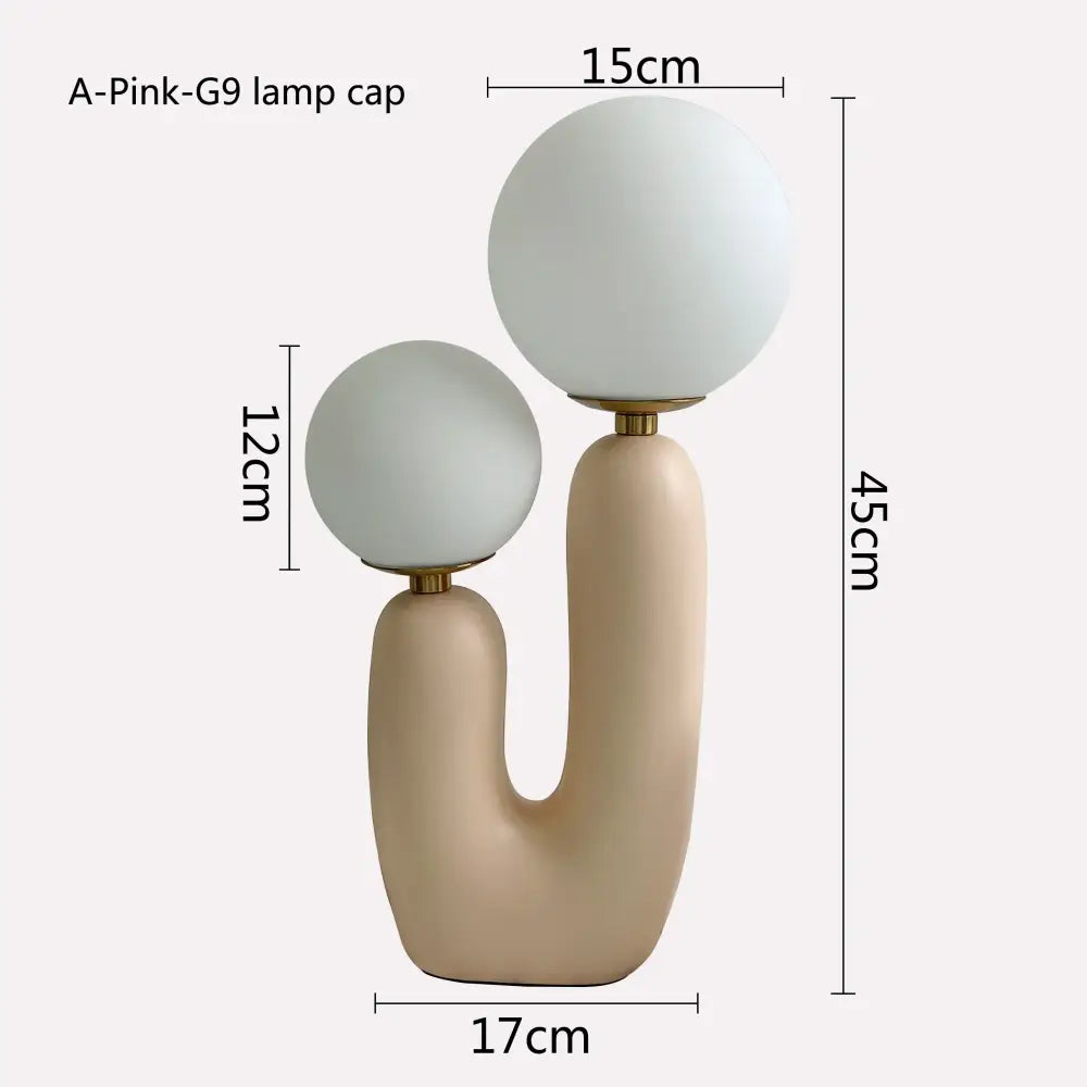 Cream-colored ceramic table lamp with two frosted glass globe shades and gold fittings for decorbites glass ball led lighting