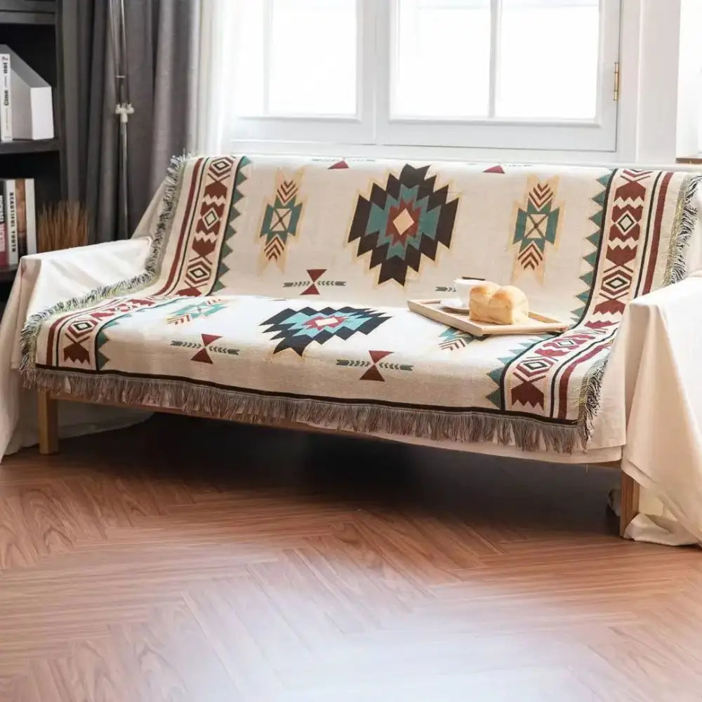 Beige bohemian sofa blanket with teal brown black geometric tribal patterns and fringed edges vintage plaid design decorbites