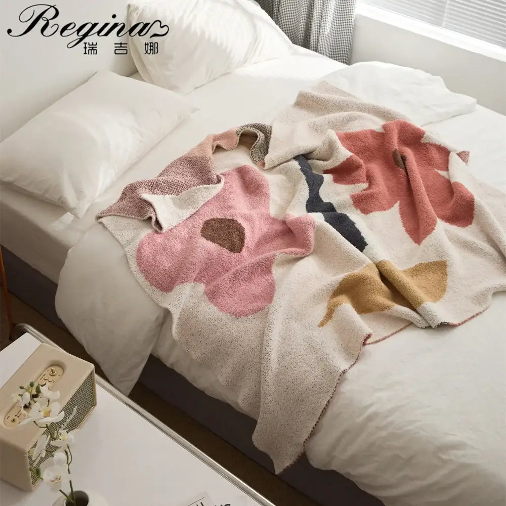 Soft cream-colored bohemian flower knitted throw blanket with oversized pink beige and navy floral decorbites design