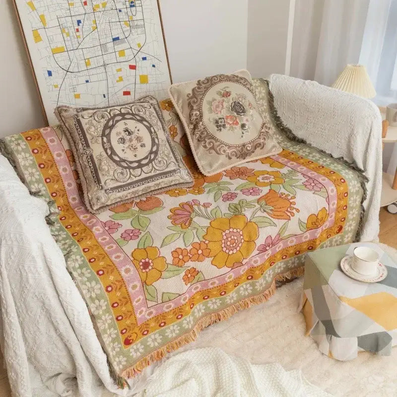 Vibrant decorbites bohemian flowers sofa blanket in warm yellow orange and pink hues with textured weave and fringed edges