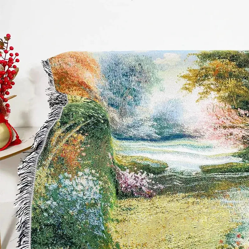 Bohemian jacquard sofa blanket with vibrant impressionist landscape of green hills blue water and blooming pink yellow trees