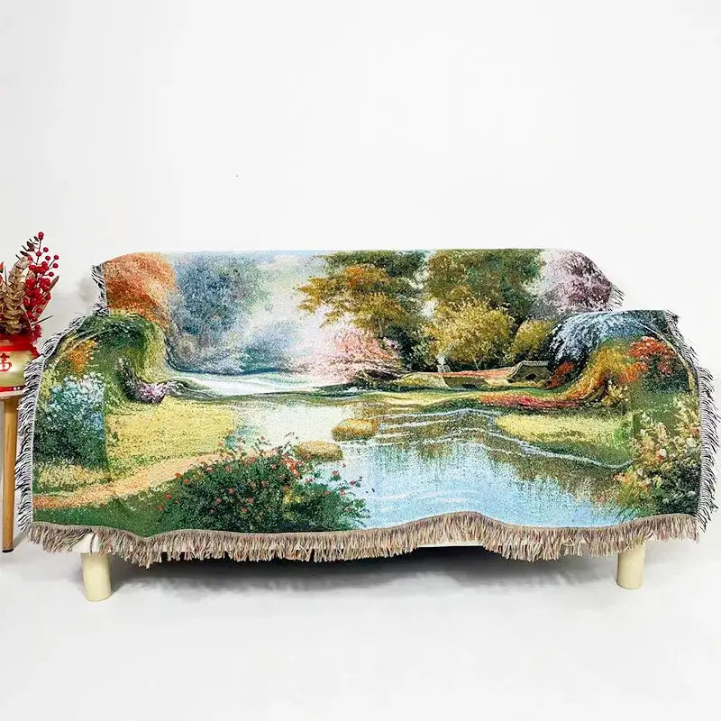 Cozy bohemian jacquard sofa blanket with vibrant pastoral autumn scene in greens blues earthy tones and fringed edges