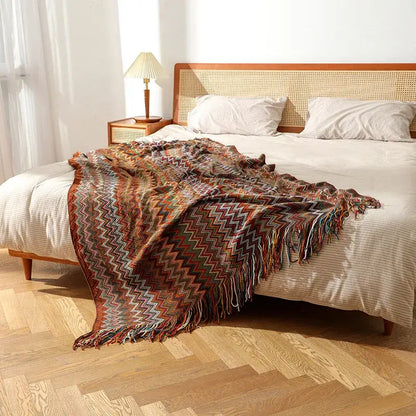 A cozy bohemian knit tassel blanket with multicolored zigzag pattern and fringed edges for bedroom decorbites decor