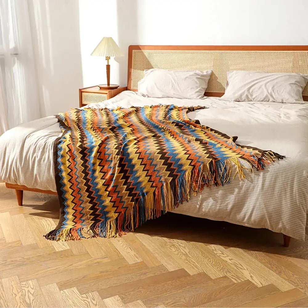 Bohemian knitted blanket with vibrant yellow blue orange and brown zigzag pattern and fringed edges for living room