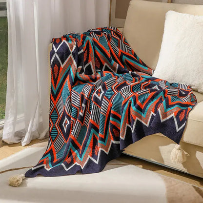 Bohemian knitted throw blanket in cream with bold navy blue teal orange geometric patterns and tassels on corners
