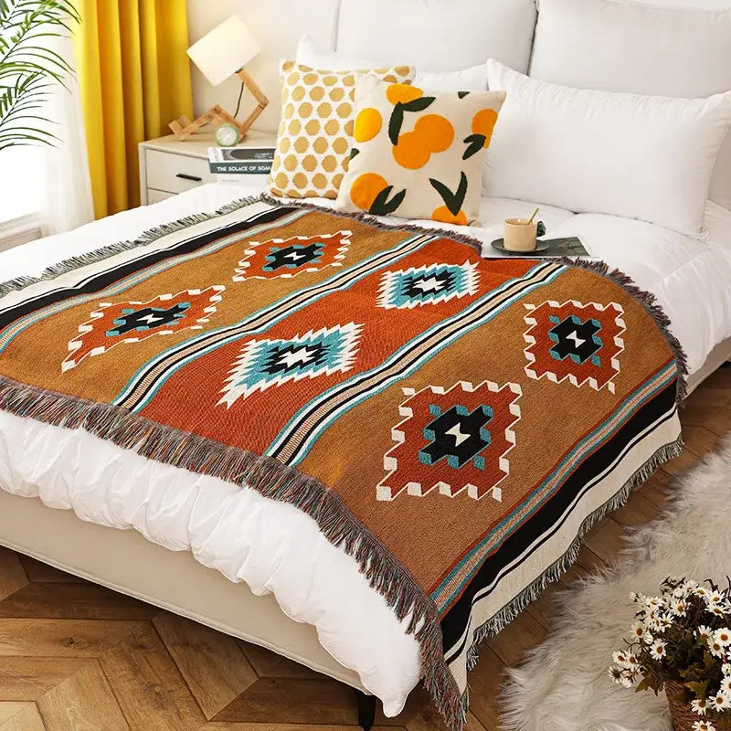 A decorbites bohemian throw blanket featuring an earth-toned orange geometric woven design with fringe edges for bedroom decor
