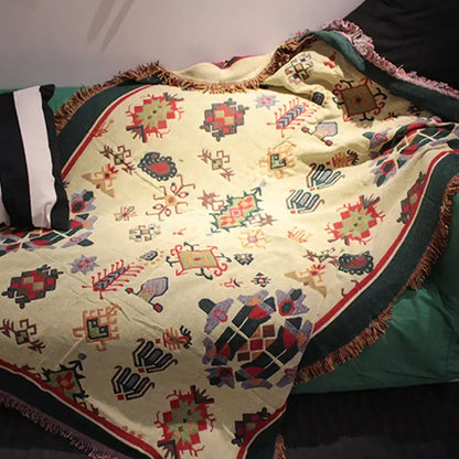 A cream-colored bohemian cotton thread knitted throw blanket with geometric patterns and fringed edges for living room decorbites
