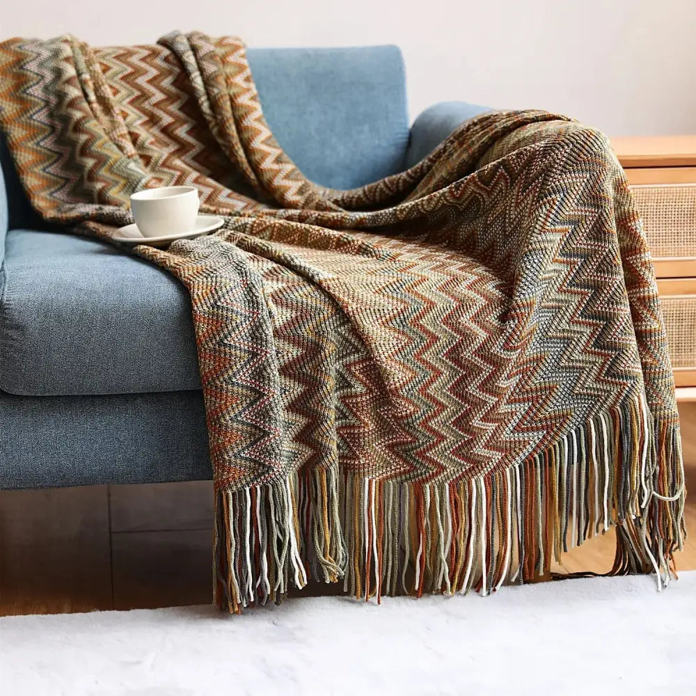 A cozy multicolored bohemian stripe throw blanket with zigzag knit pattern and fringed edges from decorbites