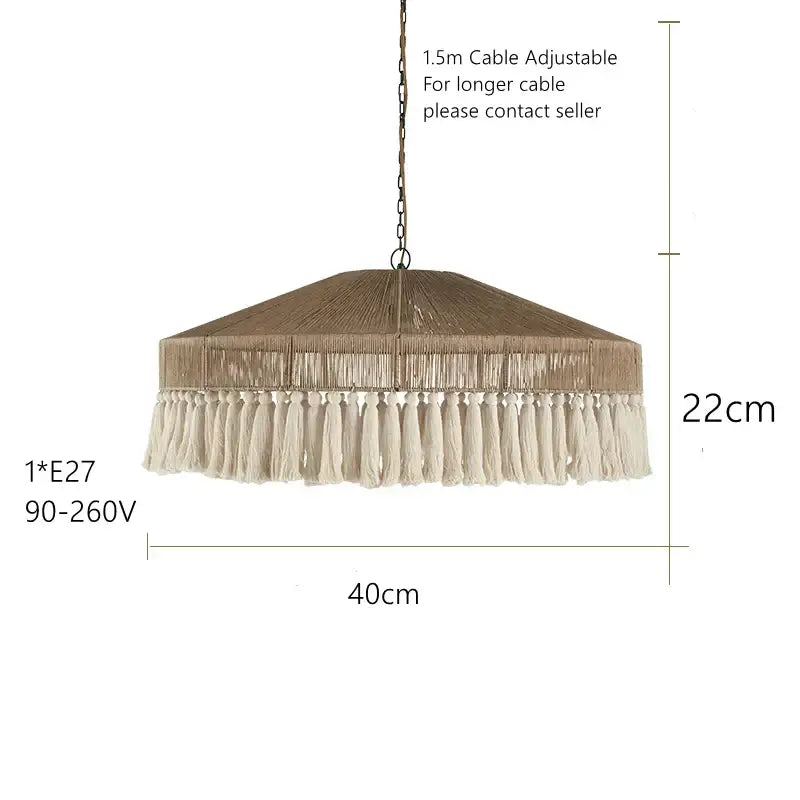 A rustic beige woven bohemian tassel chandelier with cream tassel fringe hanging from a hexagonal shade