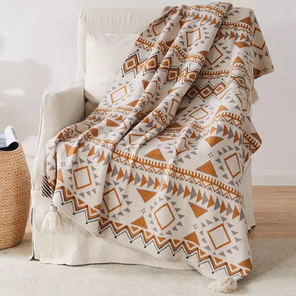 Cozy cream bohemian tassel knit blanket with geometric orange and gray pattern and corner tassels for decorbites decor
