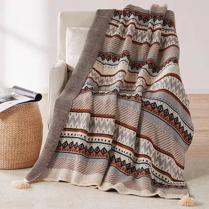 Cozy bohemian tassel knit blanket with geometric pattern in beige rust and gray featuring decorative tassels decorbites