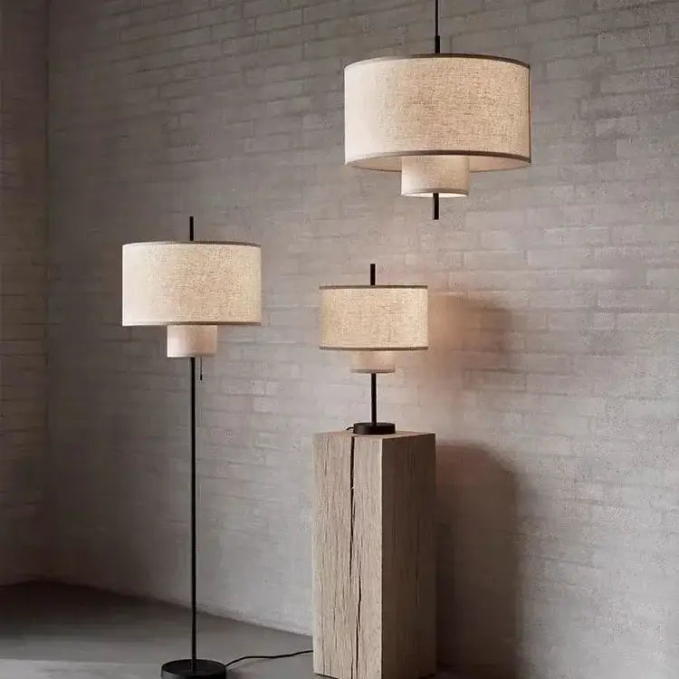 Beige linen pendant lamps with tiered design on black metal stems atop rustic wooden pedestals for living room decorbites bohemian wabi sabi