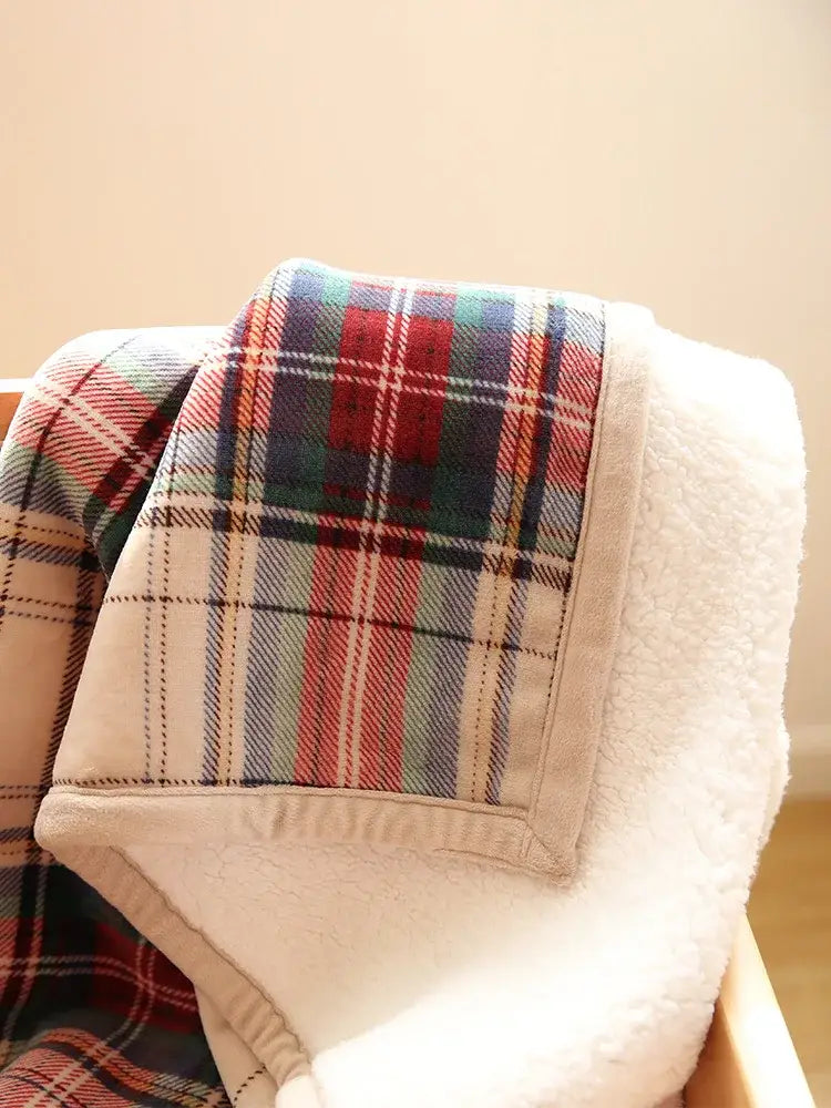Bohemian winter blanket with red green and blue plaid stripes on soft white sherpa lining for living room use