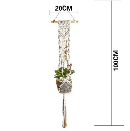 A cream-colored macrame plant hanger basket with woven geometric pattern wooden top bar and tassel for living room decor