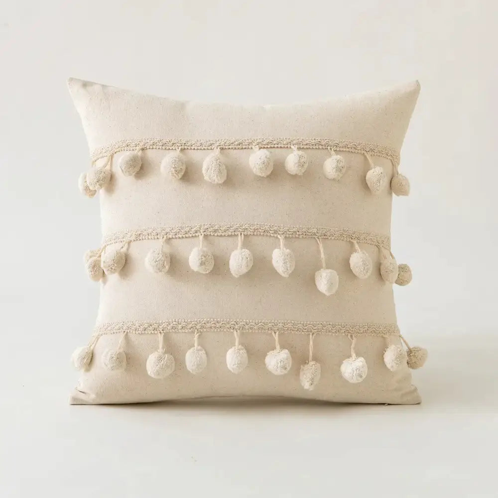Beige cotton cushion cover with three cream pom-pom rows and lace trim in decorbites beige tufted fringed style
