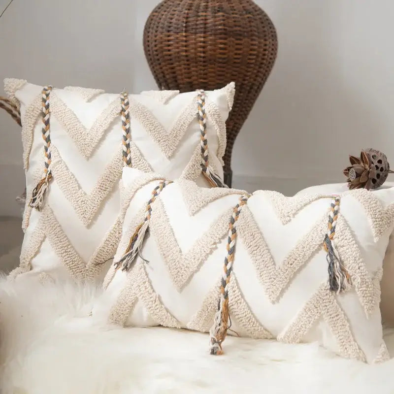 Cream-colored boho beige tufted pillow cover with textured chevron patterns and braided tassels for living room decor