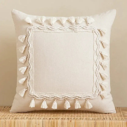 Cream-colored square pillow cover with textured embroidered border and white tassels made of linen cotton for living room decor