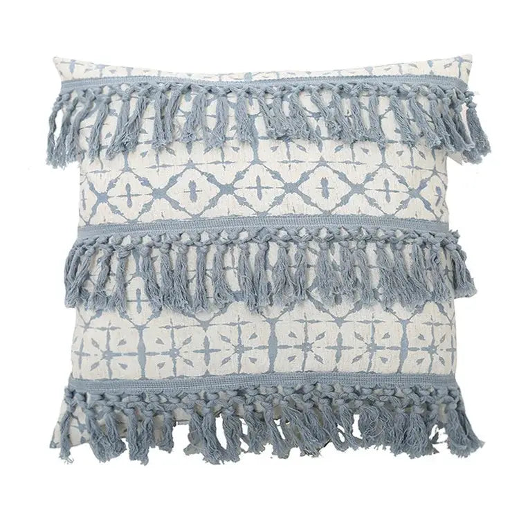 A boho blue and white tassel cushion cover with cream base light blue patterns and gray-blue fringed bands decorbites blue tassel