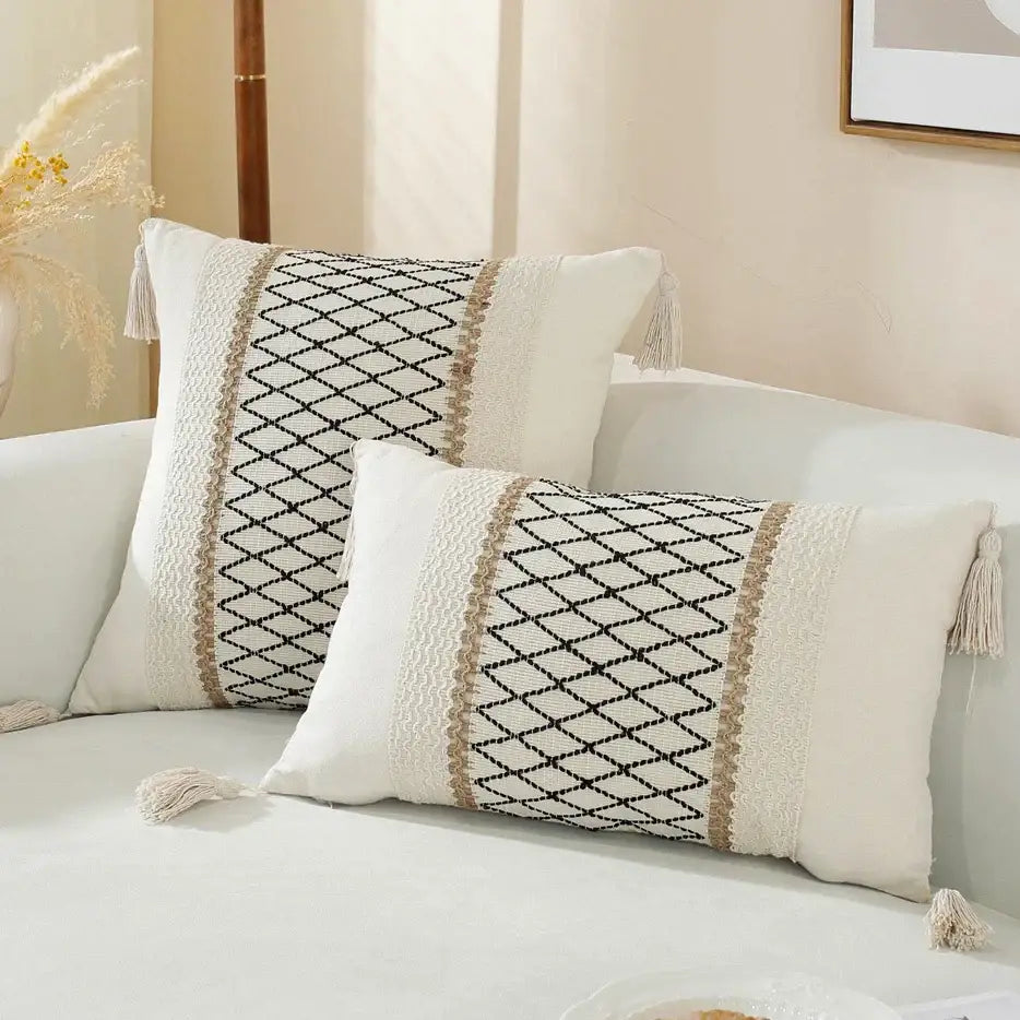 Two cream and black woven cushion covers with central diamond lattice and tasseled corners for living room decor