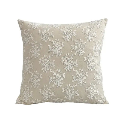 Beige cushion cover with intricate white lace floral embroidery in a boho decorbites style for living room use