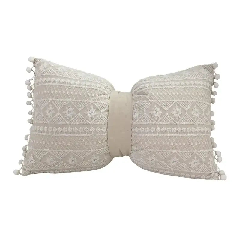 Beige bow-shaped cushion cover with intricate lace floral pattern and pom-pom trim decorbites boho white style