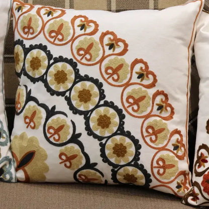 White throw pillow with intricate ethnic flower elephant embroidery in black orange and gold thread for boho decorbites decor