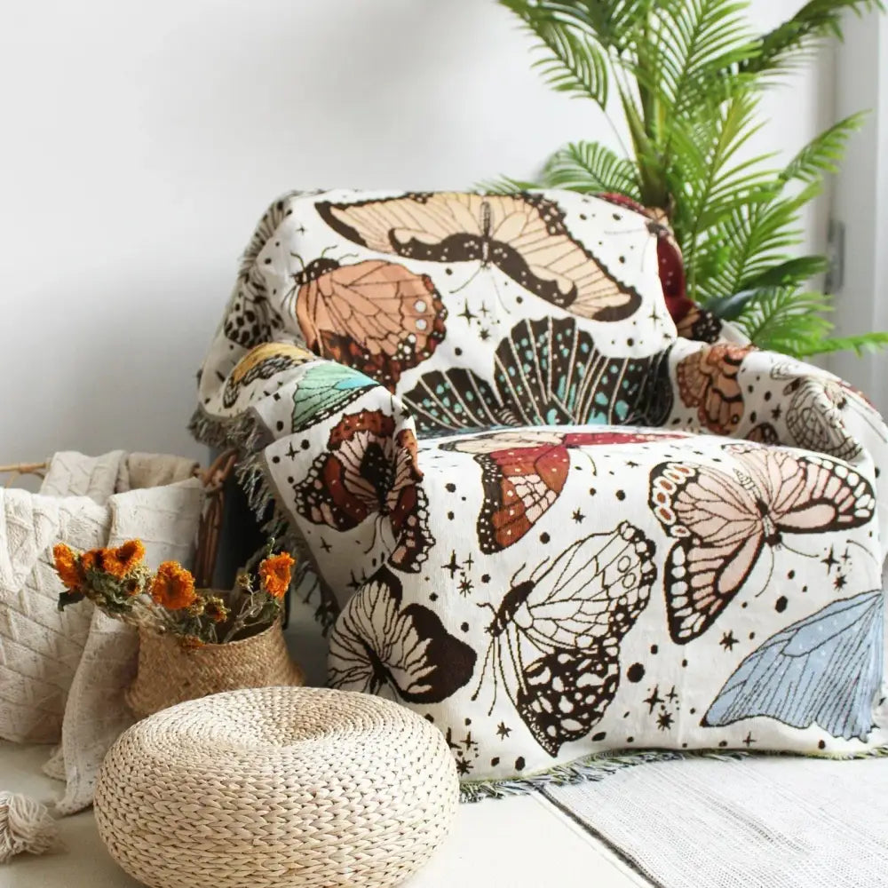 A cozy boho floral cotton blanket with multicolored butterflies and starry details draped over an armchair