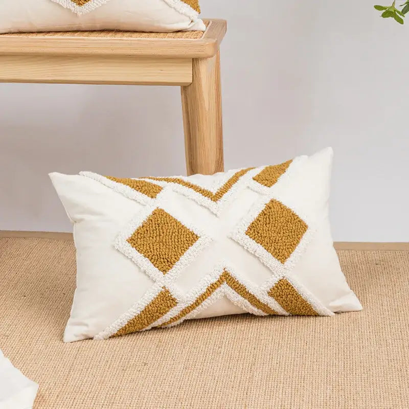 Cream-colored cushion cover with mustard-yellow geometric embroidery boho patterns and white fringe accents for living room decorbites