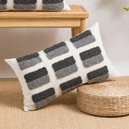 White rectangular cushion cover with decorbites geometric embroidery featuring dark and medium gray tufted stripes