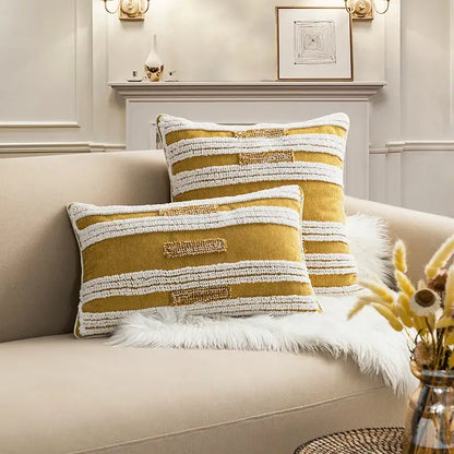 Two mustard yellow and white textured cushion covers with embroidered accents on beige sofa for decorbites boho loop tufte decor