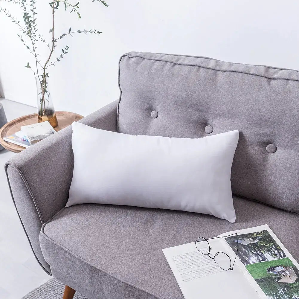 White rectangular cushion cover with gray boho geometric tufted embroidery resting on a gray sofa decorbites tufted embroidery
