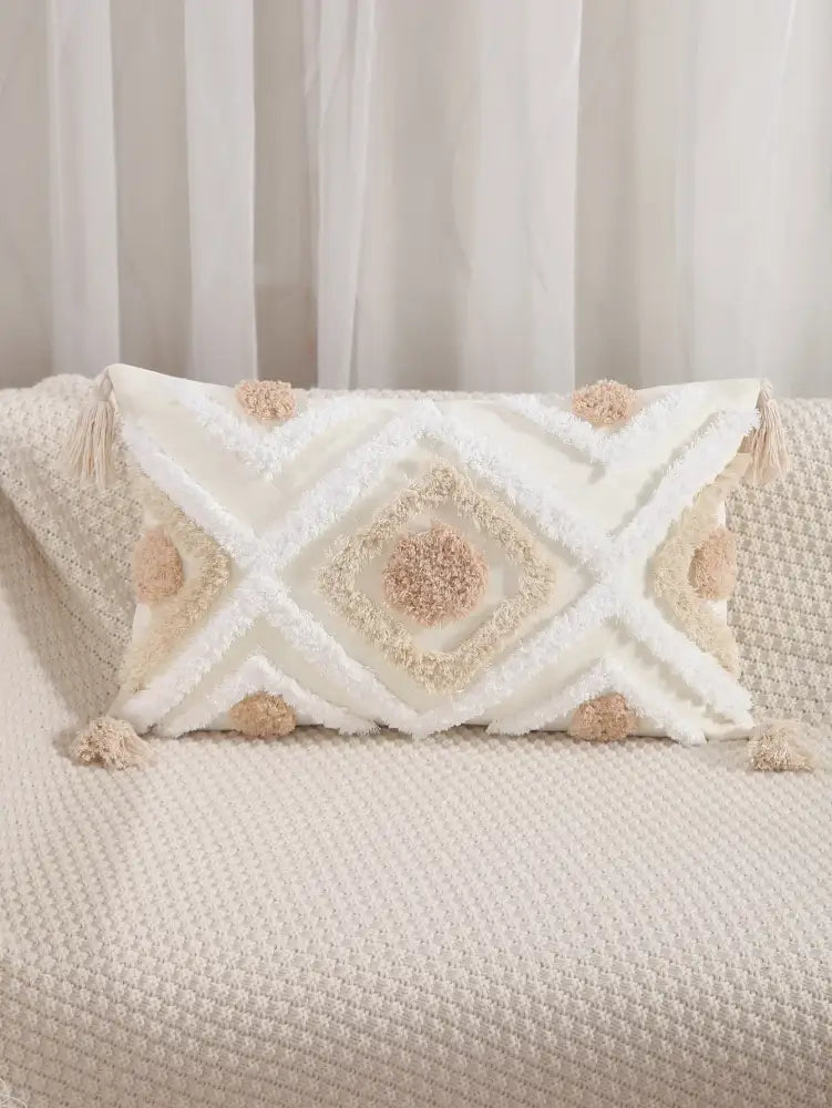 Cream-colored cushion cover with tufted embroidery and beige pom-poms for boho geometric decorbites decor