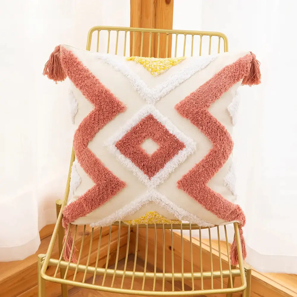 Cream-colored cushion cover with coral and yellow tufted embroidery geometric pattern and tassel decorbites tassels