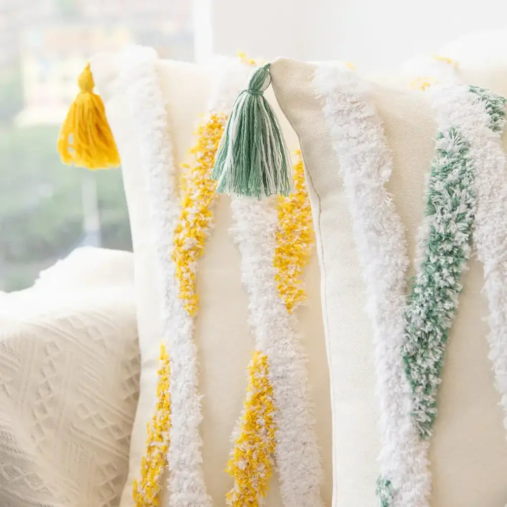 Cream-colored cushion cover with tufted embroidery featuring vertical yellow and green tassels for boho living room decorbites geometric tufted decor