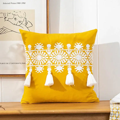 Vibrant yellow boho gold embroidered cotton pillow cover with intricate white patterns and tassels by decorbites