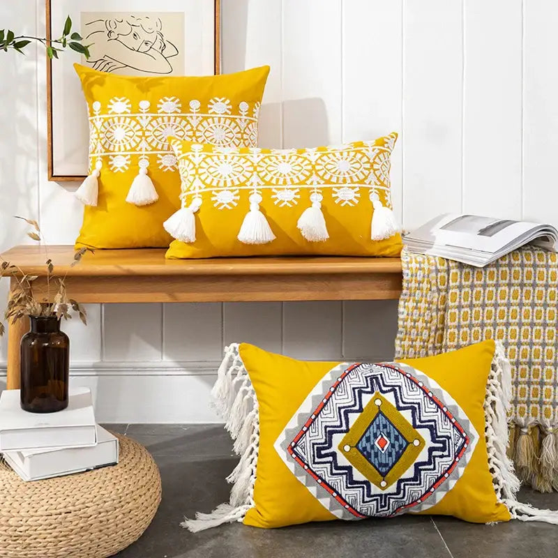 Vibrant yellow boho gold embroidered cotton pillow cover with white blue red geometric embroidery and tassel decor