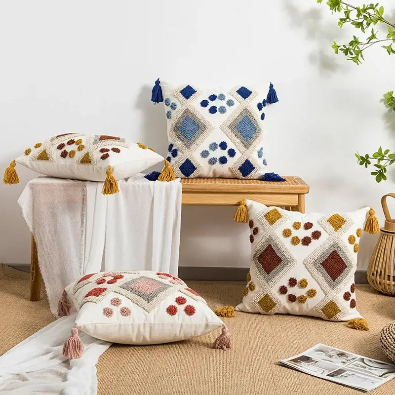 White cushion pillow cover with boho loop tufted geometric patterns in blue brown yellow yarns and tassel accents