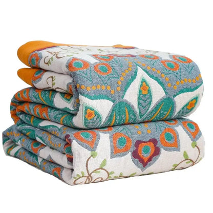 Stacked folded summer blankets featuring vibrant teal and orange decorbites boho mandala cotton patterns on textured fabric