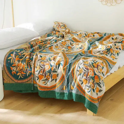 A cozy boho mandala cotton summer blanket with vibrant orange and green floral motifs on cream background