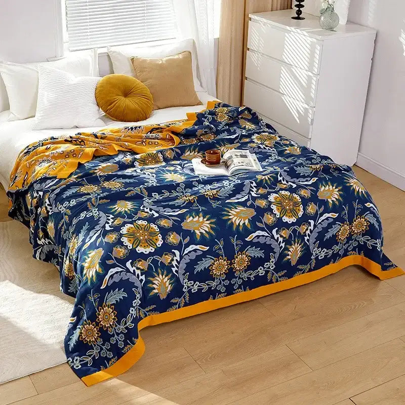 A navy blue and gold floral boho mandala cotton summer blanket with a solid yellow border for bedroom decor
