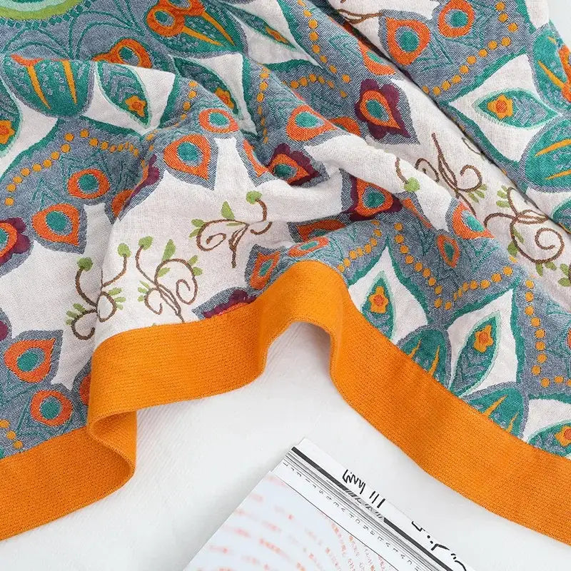 A lightweight boho mandala cotton summer blanket with vibrant teal orange paisley and orange knitted border decorbites boho mandala