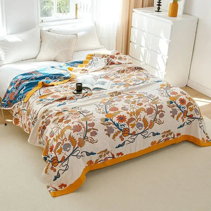 A cream-colored boho mandala cotton summer blanket with vibrant orange blue floral pattern and embroidered border