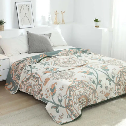 A soft cream-colored boho mandala cotton summer blanket with floral paisley pattern in muted orange green and brown tones