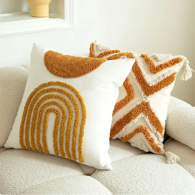 White throw pillow cushion cover with mustard yellow geometric tufted embroidered rainbow and chevron patterns and cream tassels