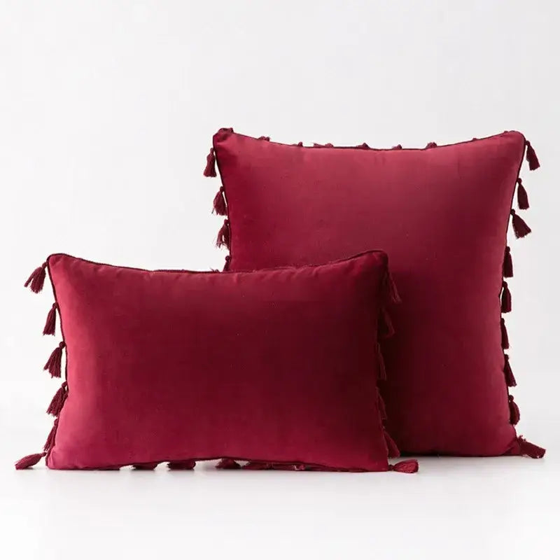 Deep red velvet pillow covers with decorative tassel fringe edges for elegant boho home decor living room accents